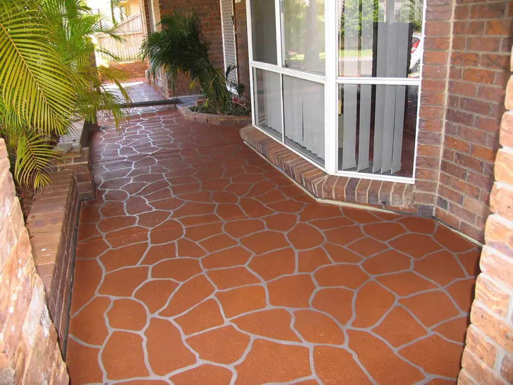 Terracotta bush rock crazy paving pattern in decorative concrete resurfacing along a covered brick verandah